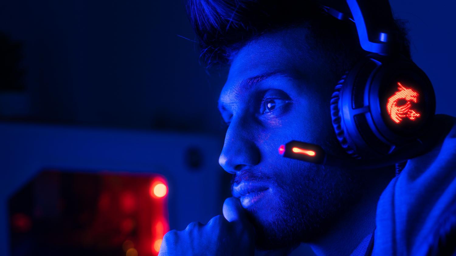 Gamer concentrado utilizando auriculares de alta calidad para reducir el lag de audio.