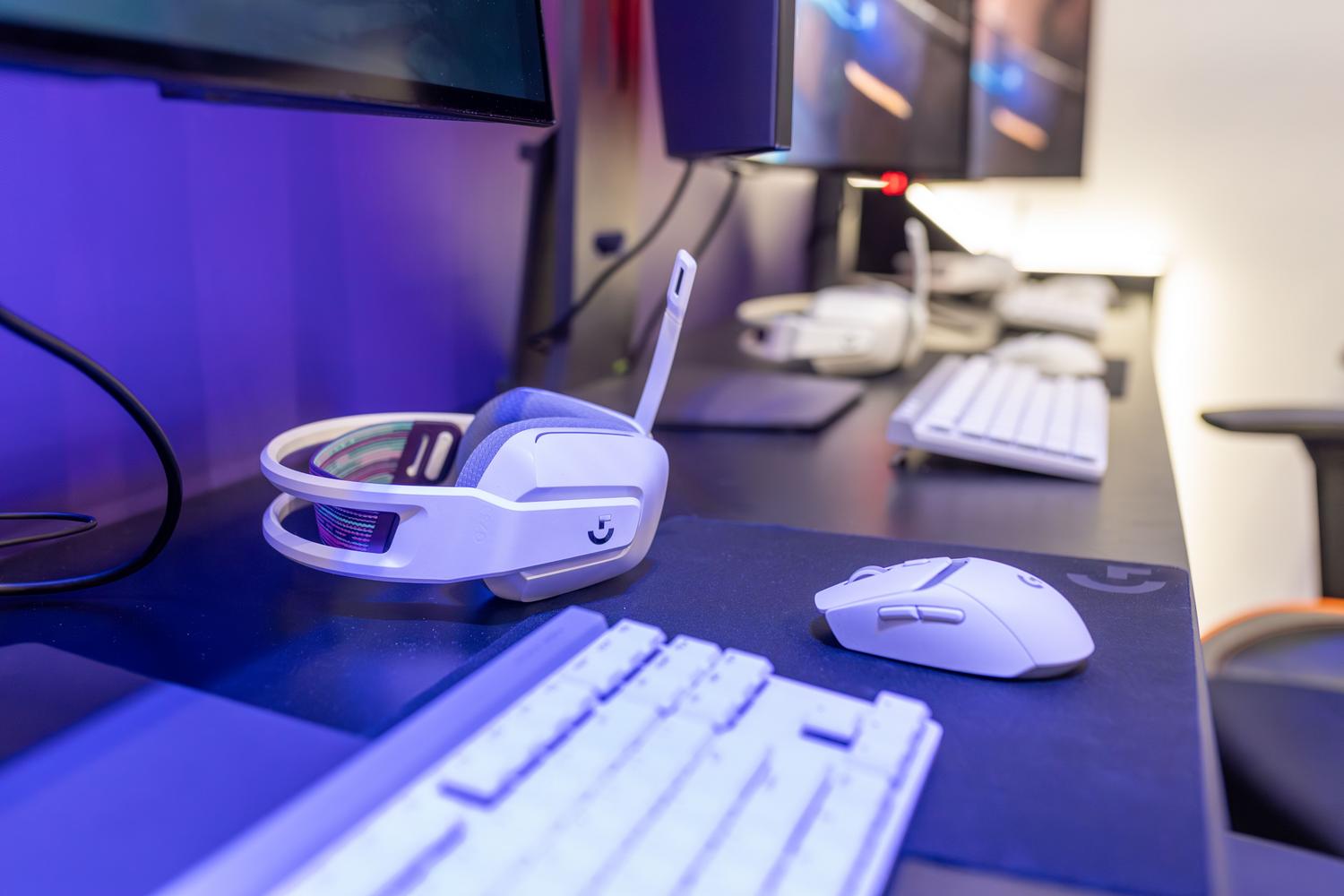 Setup de gaming moderno con auriculares y teclado RGB, ideal para juegos de ritmo.