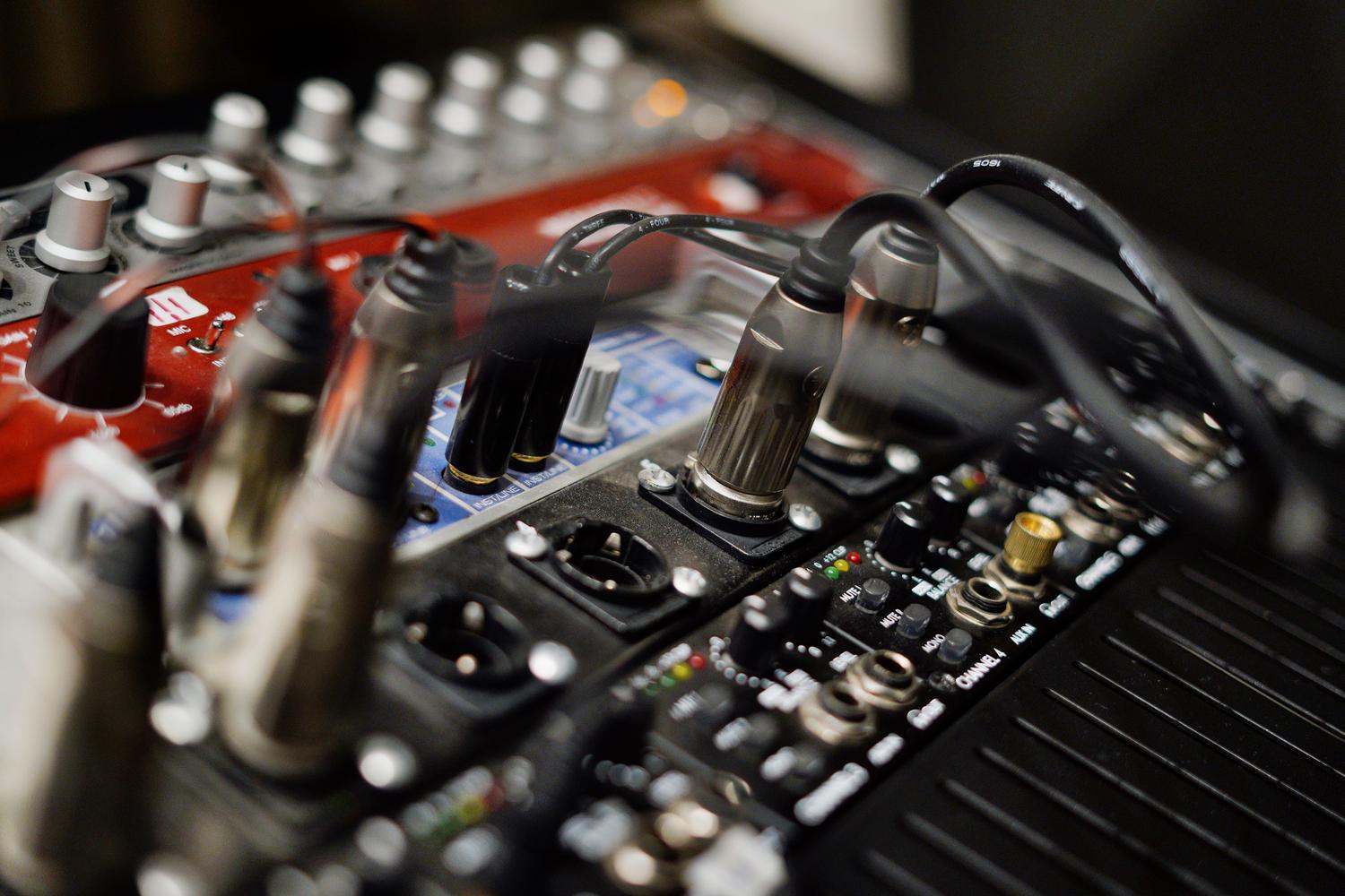 Detalle de conexiones de cables en una interfaz de audio profesional para baja latencia.