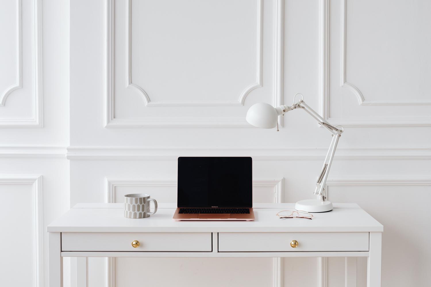 Espacio de trabajo luminoso y minimalista con MacBook Air, ideal para ilustrar la limpieza visual y la organización digital.