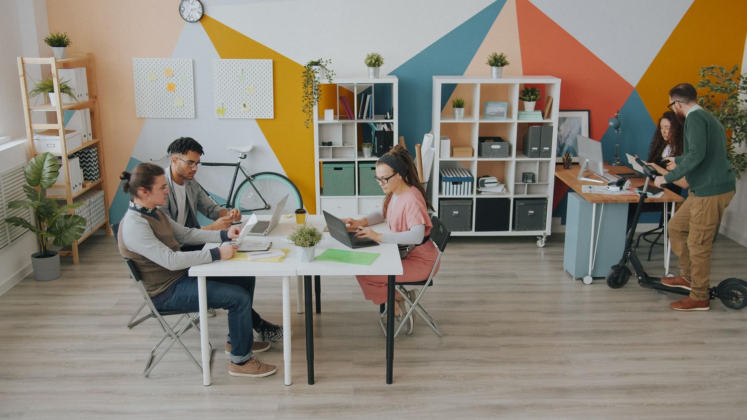 Equipo diverso de profesionales colaborando en un espacio de oficina moderno y creativo, ilustrando el trabajo en equipo potenciado por herramientas de IA.