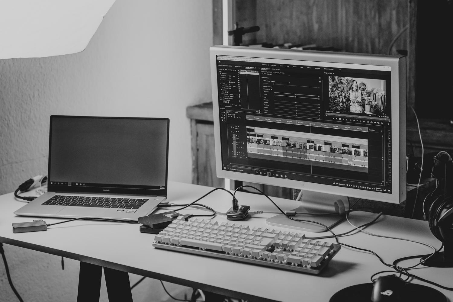 Espacio de trabajo tecnológico minimalista en blanco y negro optimizado para la postproducción de vídeo.
