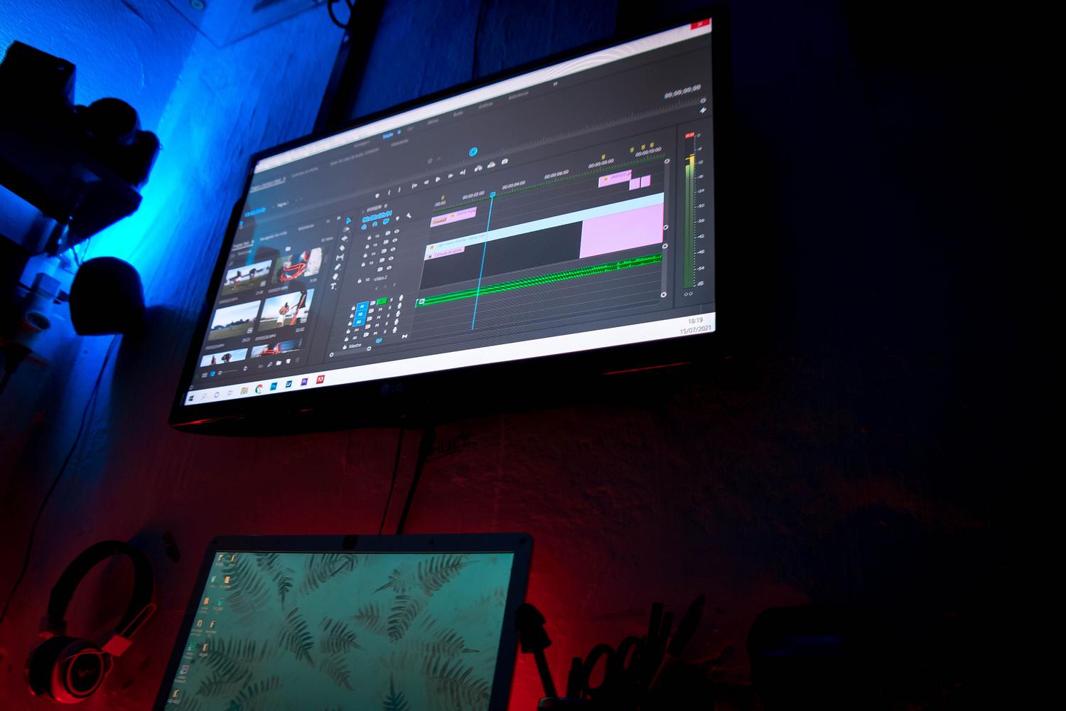 Estación de trabajo moderna con doble monitor mostrando el proceso de renderizado y gestión de archivos de vídeo.
