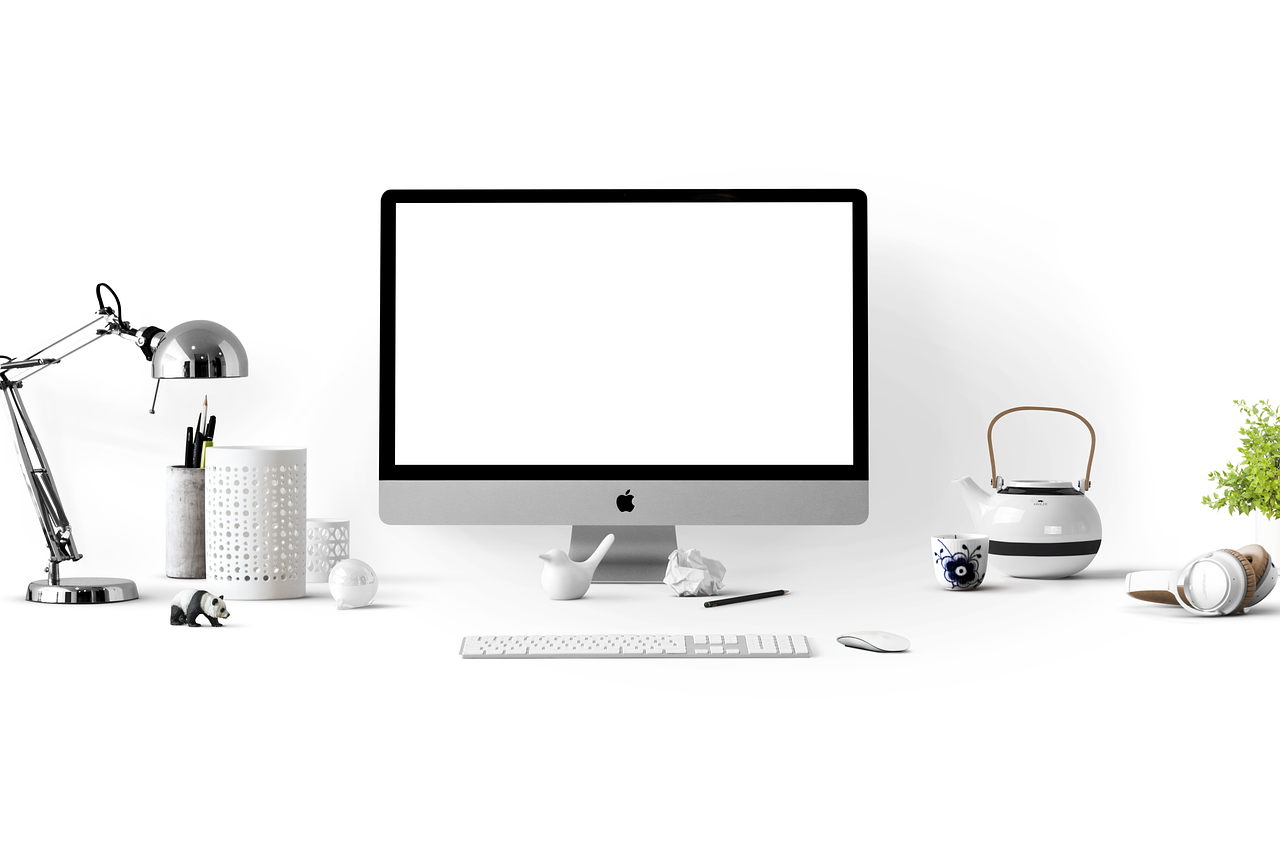 Espacio de trabajo moderno y limpio con un Apple iMac sobre un escritorio blanco brillante, evocando un entorno de trabajo optimizado.