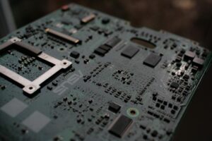 Bilgisayar anakartının devrelerini ve elektronik bileşenlerini vurgulayan teknik detayları.