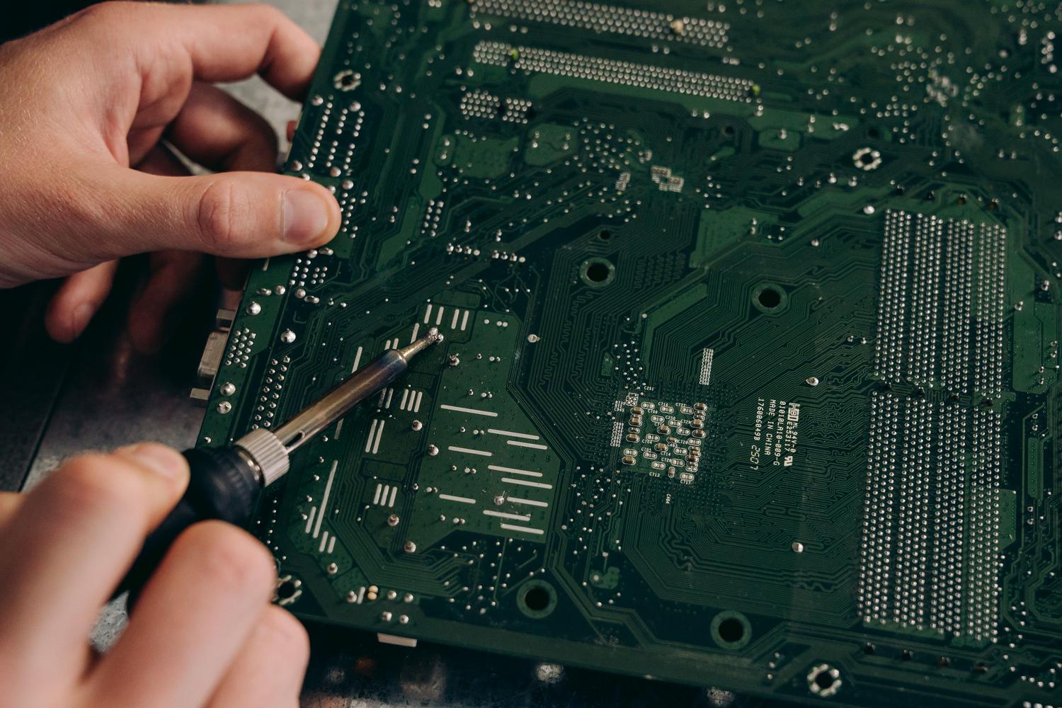 Técnico realizando una reparación de soldadura de precisión sobre una placa base