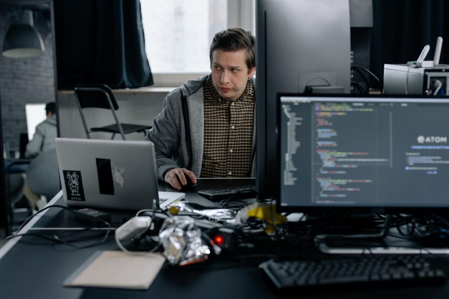 Programador frustrado analizando un error de código en su ordenador mientras intenta diagnosticar un fallo de automatización