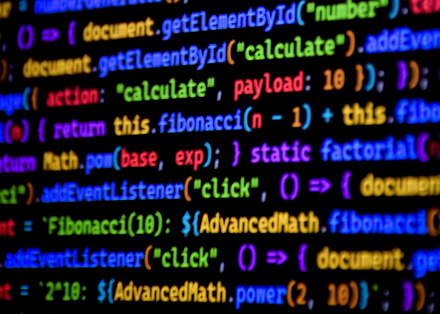 Detalle macro de código de programación con resaltado de sintaxis colorido sobre fondo negro.