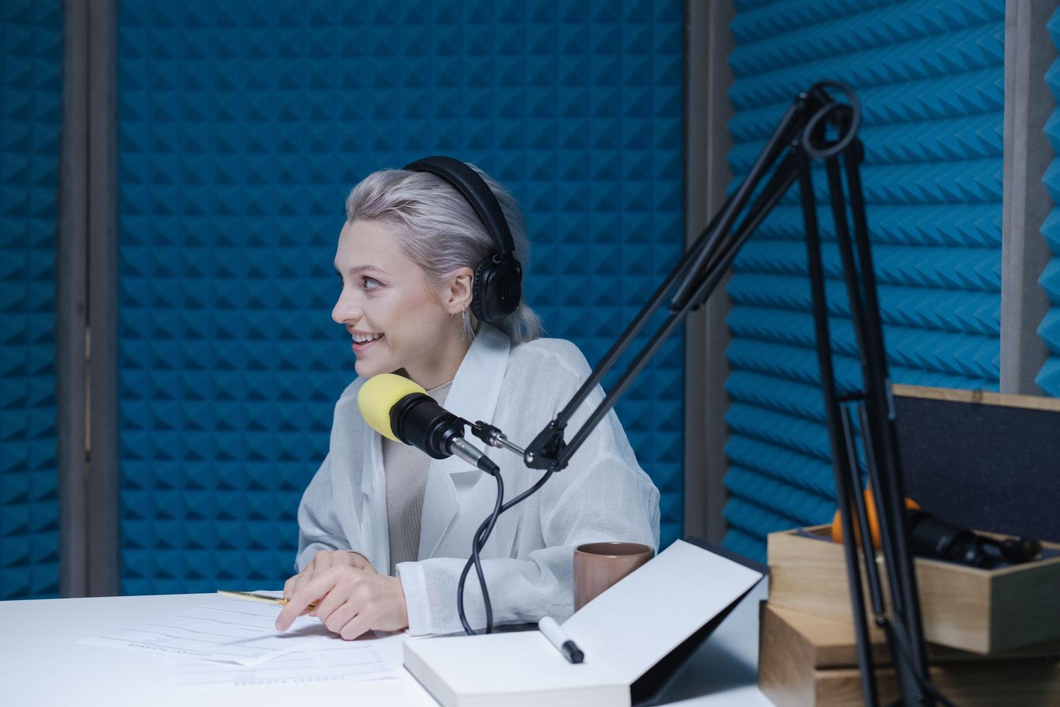 Mujer grabando un podcast en un estudio insonorizado, destacando la importancia de la calidad vocal en entornos educativos y profesionales.