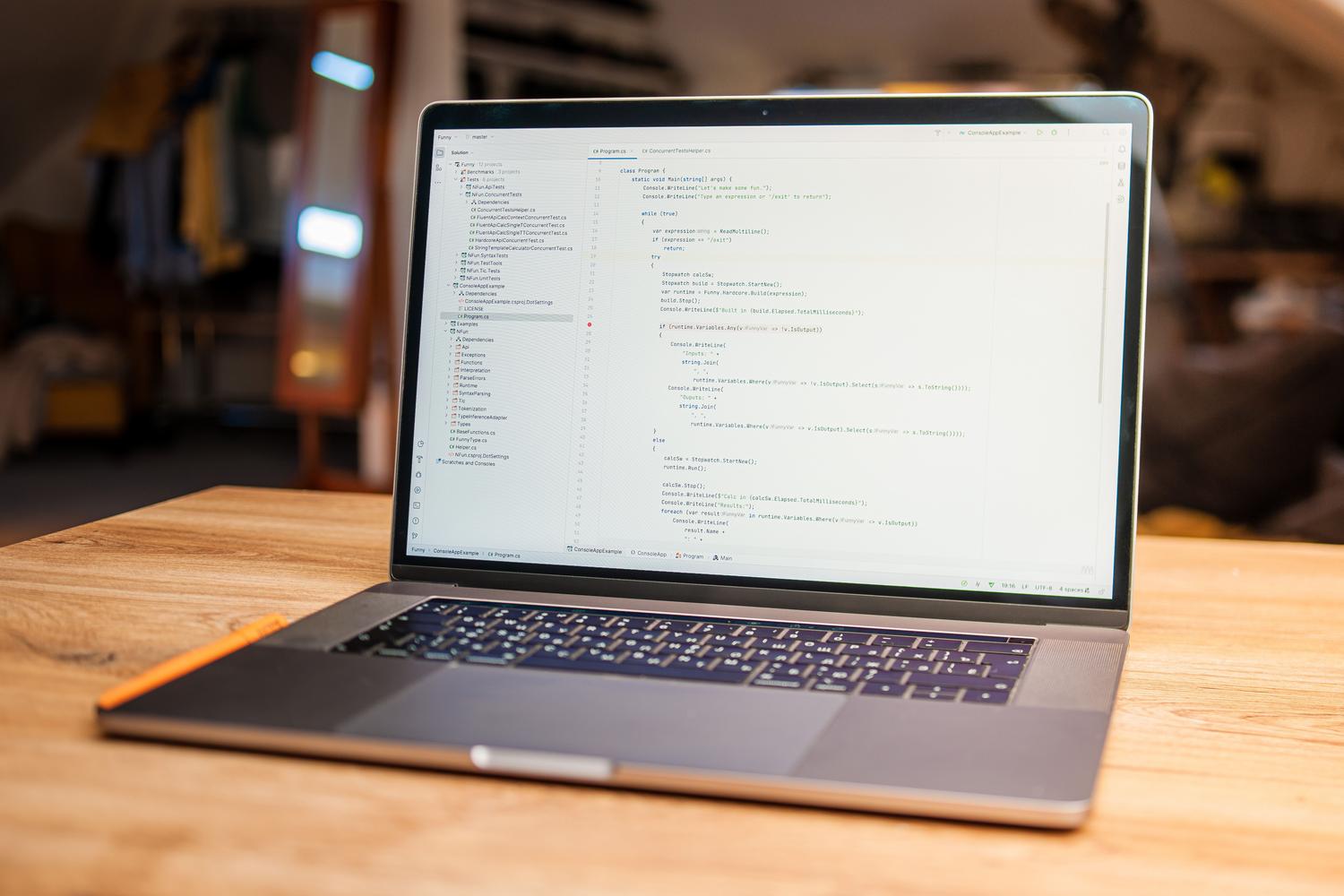 Espacio de trabajo minimalista y organizado con un portátil mostrando código fuente en C#.