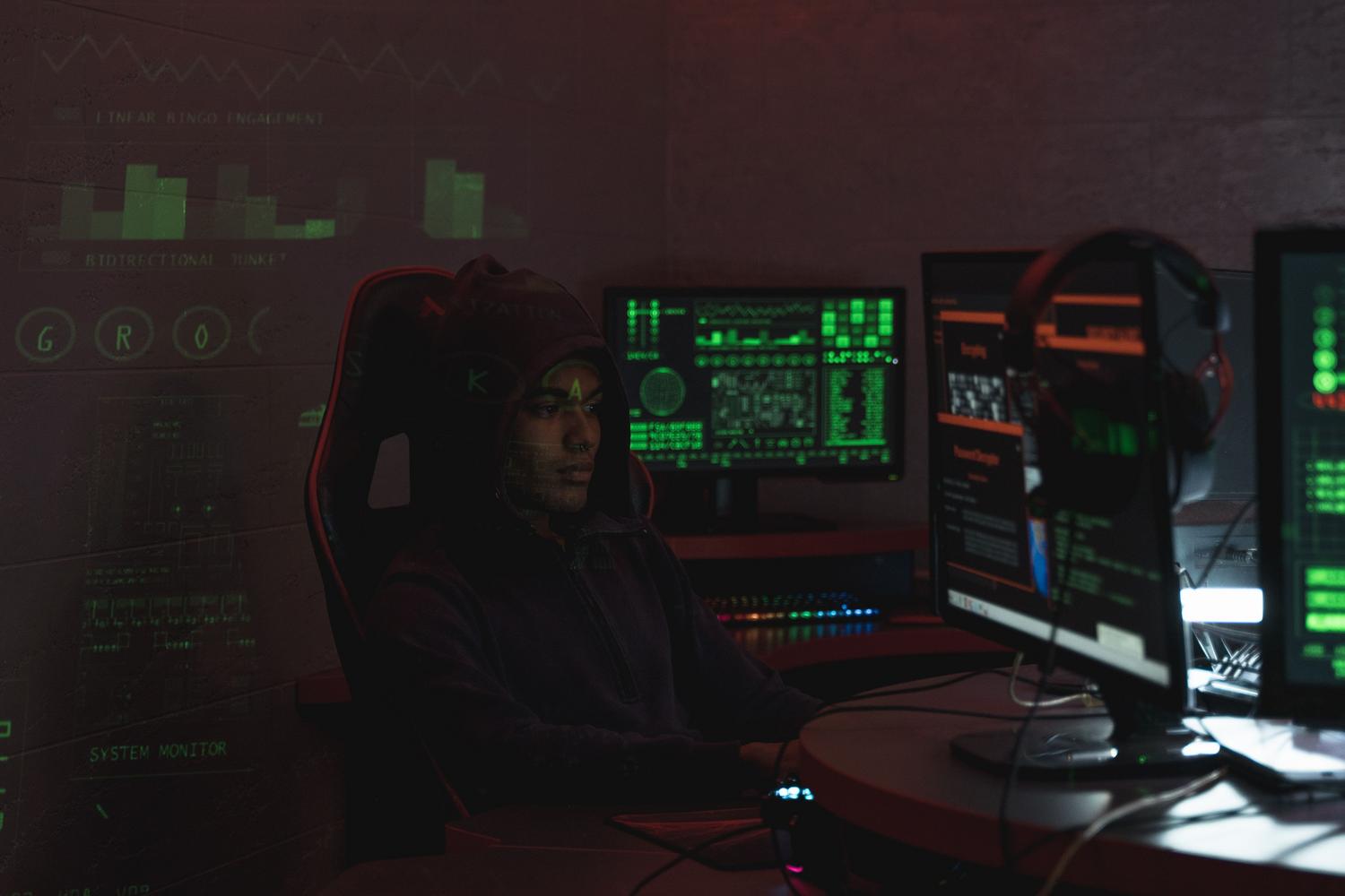 Analista de seguridad utilizando múltiples monitores para procesar y analizar diversas fuentes de datos simultáneamente. Analista de seguridad utilizando múltiples monitores para procesar y analizar diversas fuentes de datos simultáneamente.