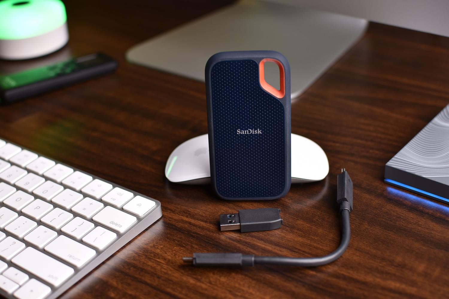 Unidad SSD portátil SanDisk con cables y adaptadores USB, representando la preparación y formateo de discos externos en macOS.