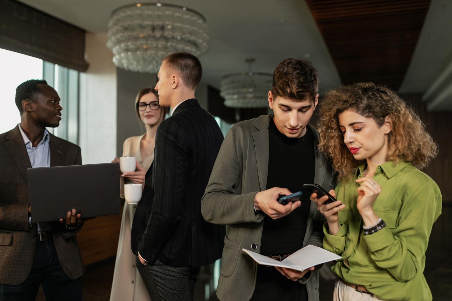 Grupo de profesionales de negocios utilizando smartphones, ejemplificando los modelos de gestión BYOD y COPE en la empresa.