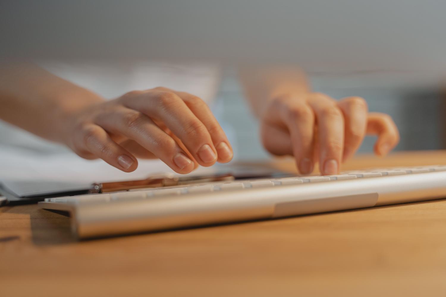 Manos escribiendo en un teclado, representando el acceso a la BIOS mediante teclas de función