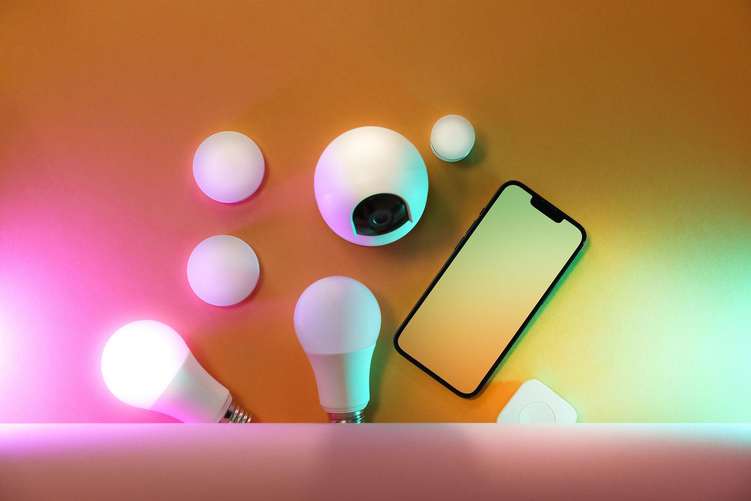 Conjunto de dispositivos IoT como bombillas inteligentes y un teléfono móvil