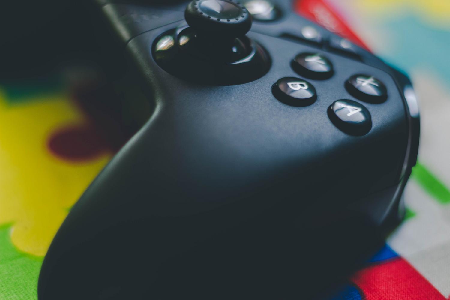 Detalle macro de los botones y el stick analógico de un mando de juegos negro. Detalle macro de los botones y el stick analógico de un mando de juegos negro.