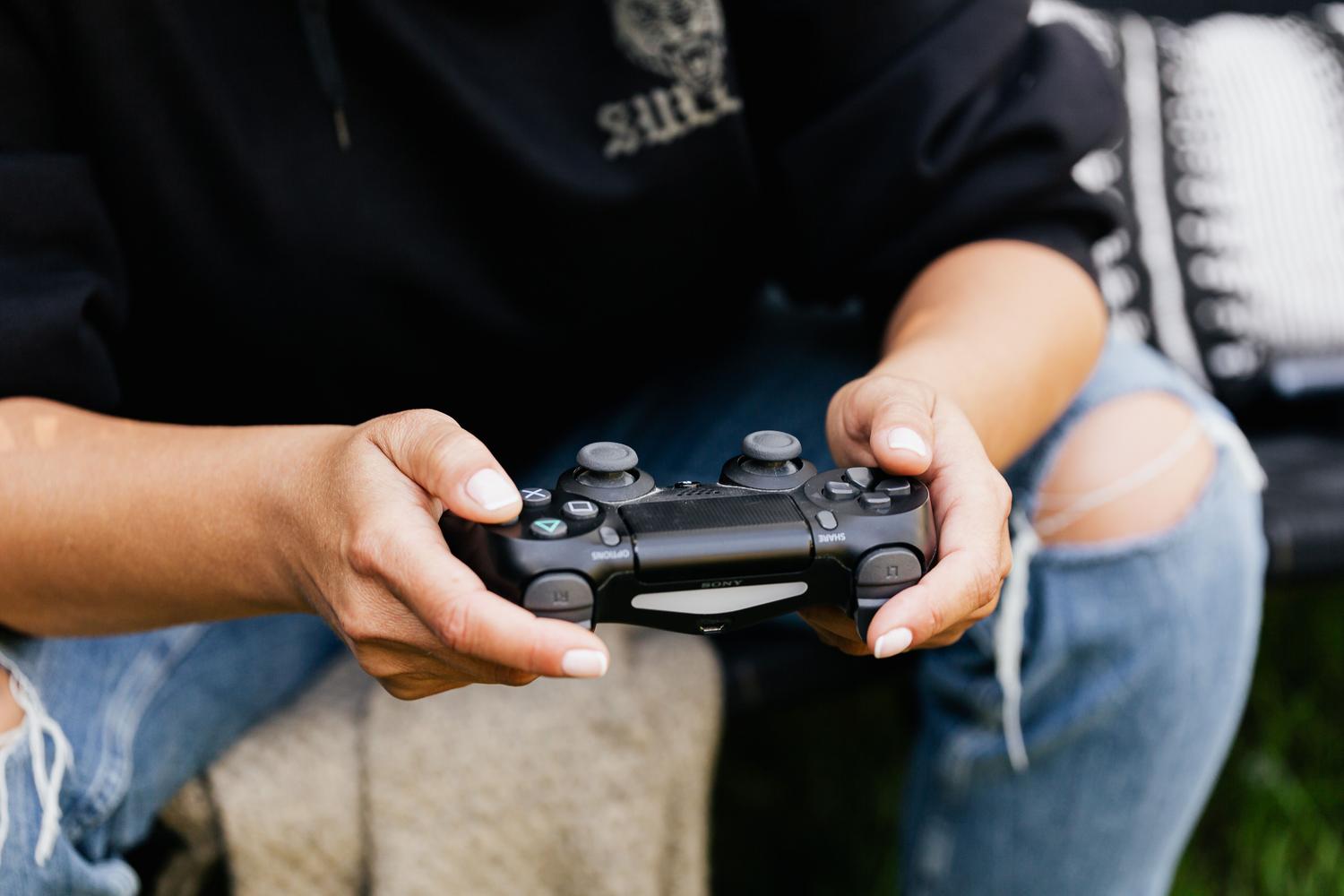 Primer plano de las manos de un usuario sosteniendo un mando de videojuegos, ilustrando la ergonomía y la experiencia física de juego.