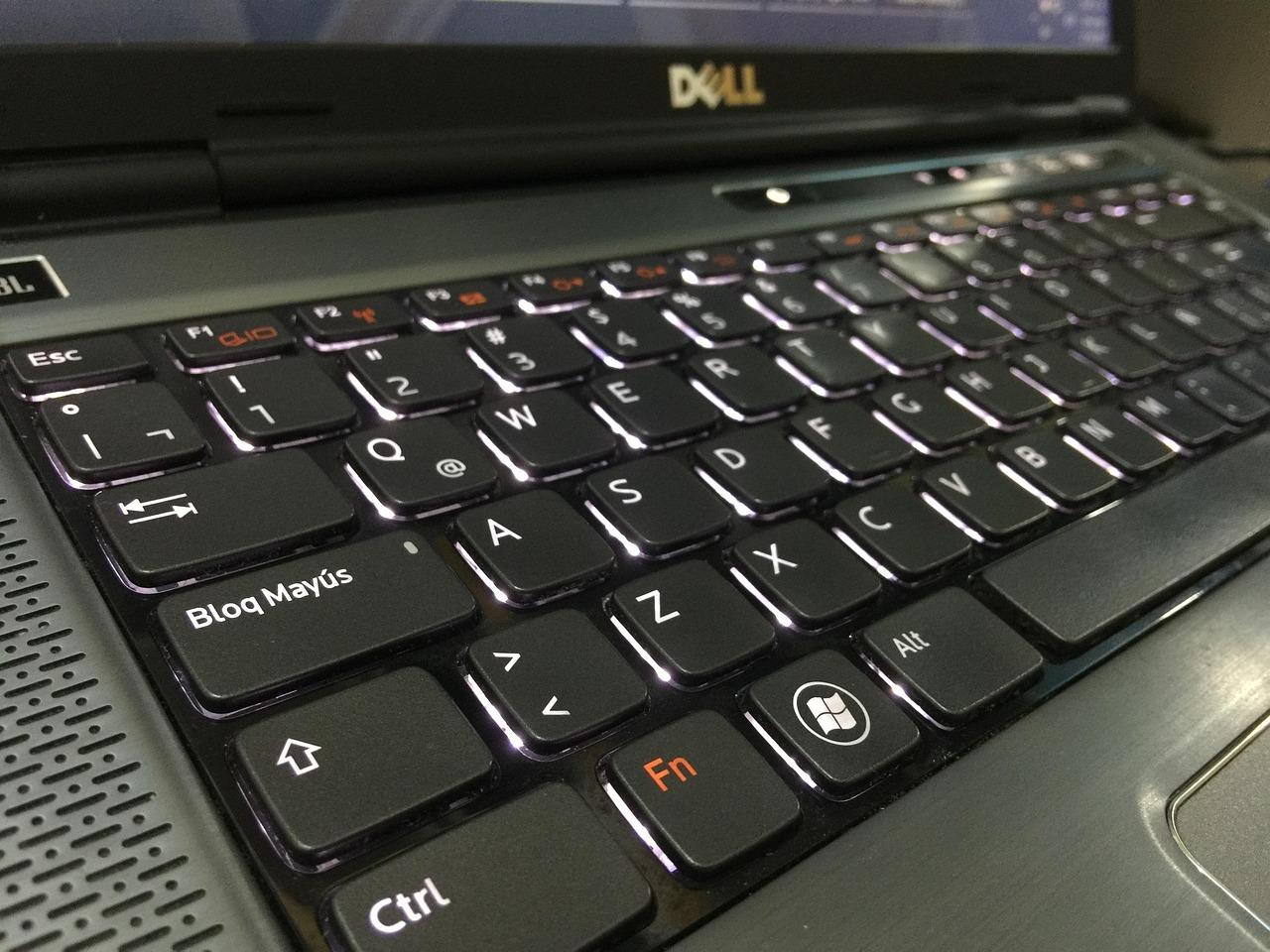 Primer plano de un teclado de portátil iluminado destacando la retroiluminación LED.