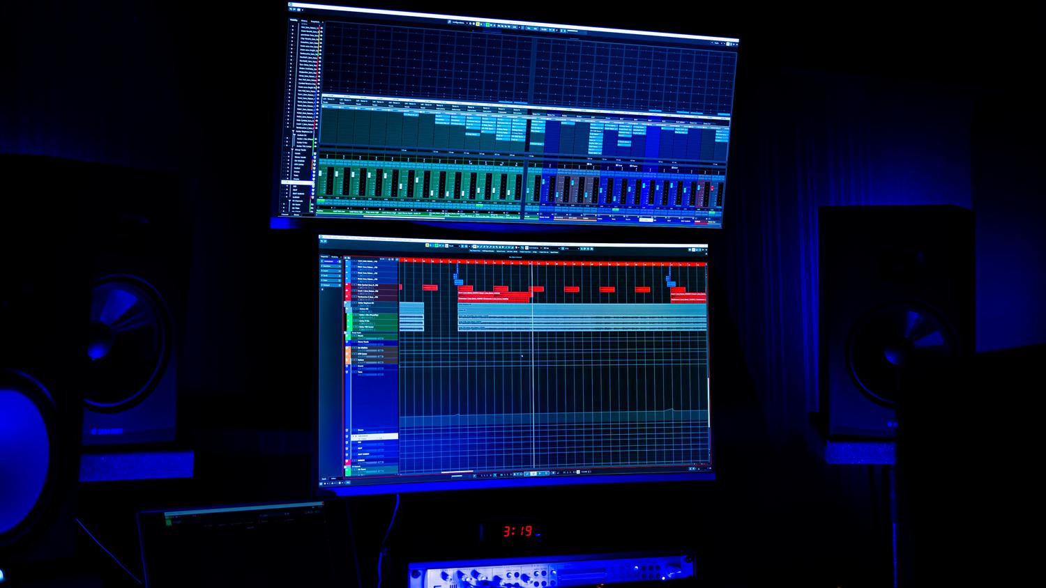Estudio de grabación moderno con pantallas de edición de audio y luces de neón azules Estudio de grabación moderno con pantallas de edición de audio y luces de neón azules