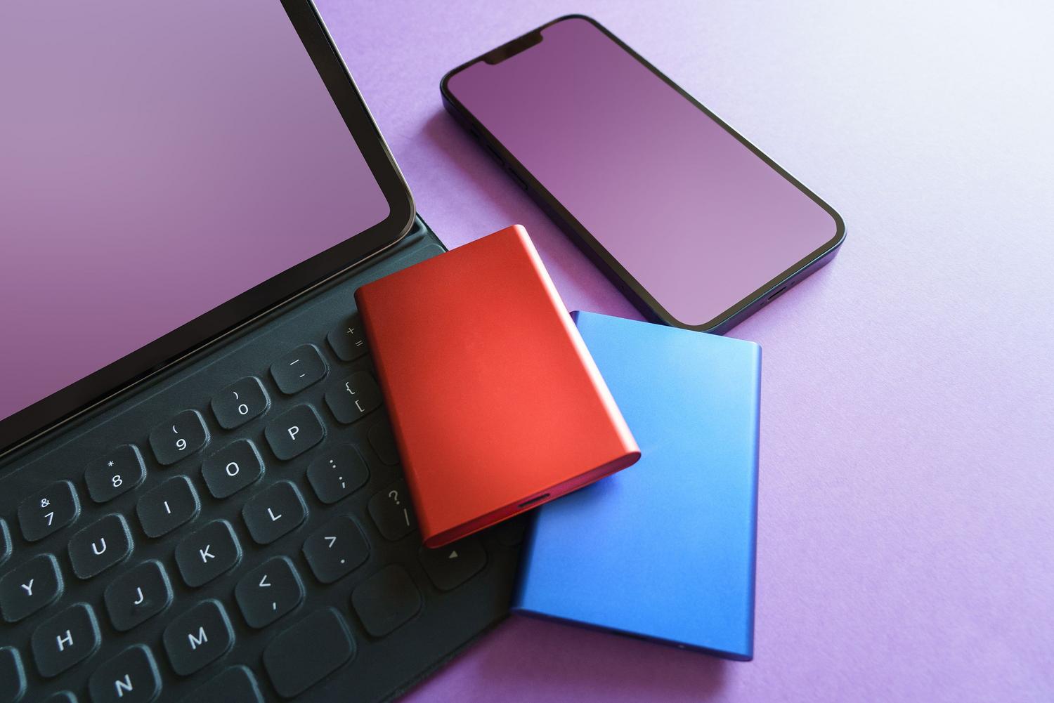 Conjunto de dispositivos tecnológicos que incluye un smartphone y un disco SSD externo para respaldar archivos.