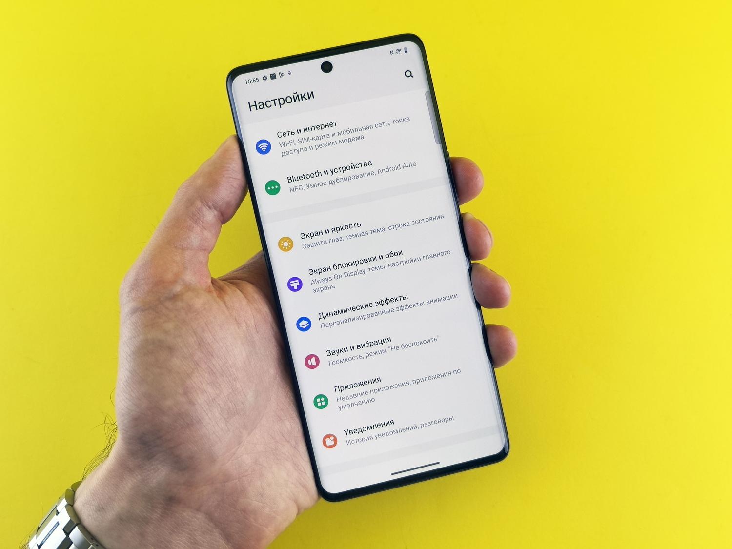 Primer plano de una mano sosteniendo un smartphone mostrando el menú de ajustes para configurar las notificaciones.