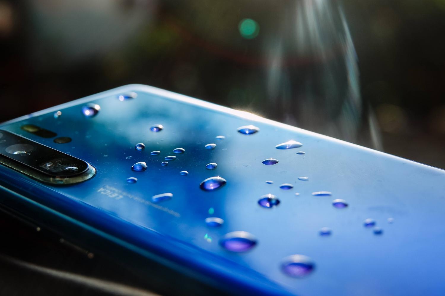 Smartphone con gotas de agua en la parte trasera, ilustrando la condensación y humedad en la cámara Smartphone con gotas de agua en la parte trasera, ilustrando la condensación y humedad en la cámara