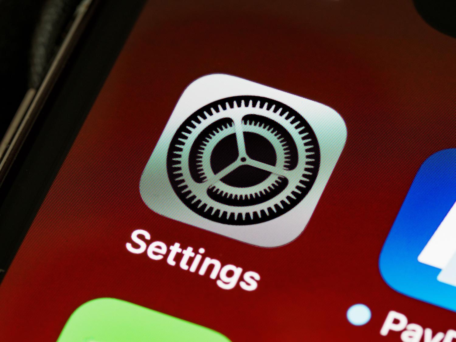 Vista detallada del icono de la aplicación de Ajustes en la pantalla de un iPhone, ideal para los pasos de configuración. Vista detallada del icono de la aplicación de Ajustes en la pantalla de un iPhone, ideal para los pasos de configuración.