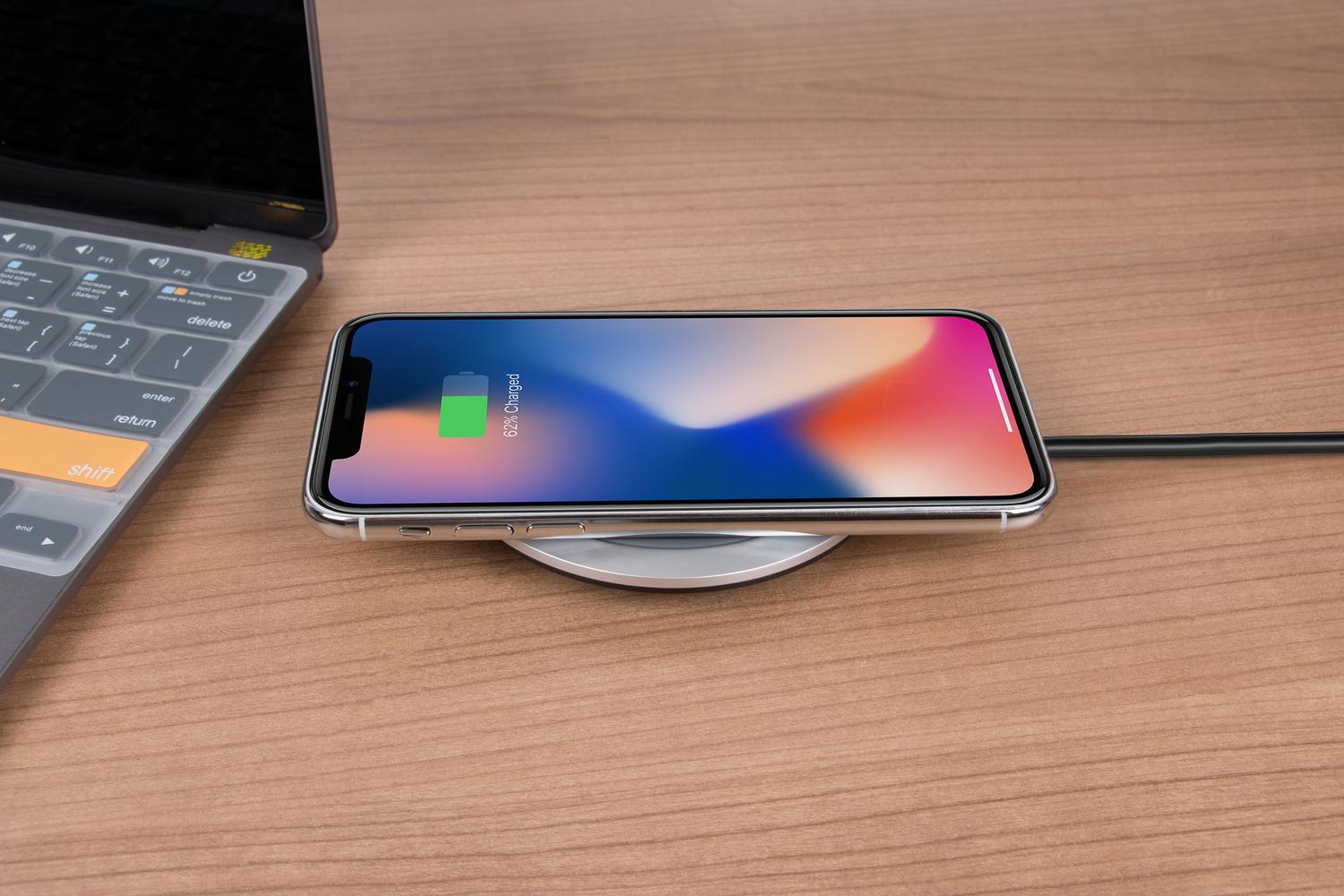 iPhone conectado a un cargador inalámbrico en un escritorio para solucionar posibles problemas de energía.