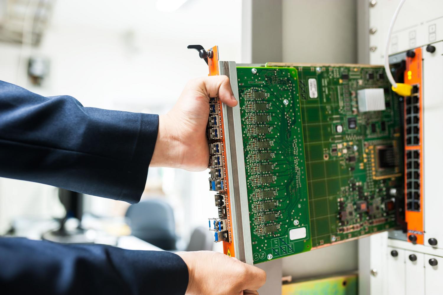 Detalle de un técnico insertando un componente de hardware en un rack, ilustrando el proceso de sustitución de piezas.