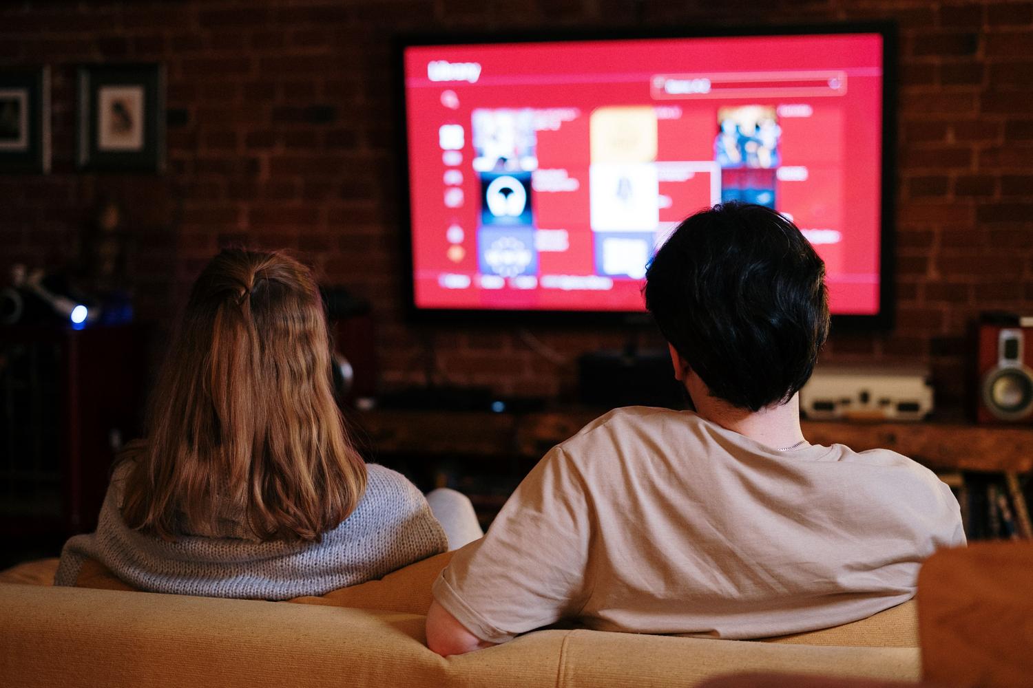 A couple enjoying high-quality streaming content on a large TV in a cozy home environment.