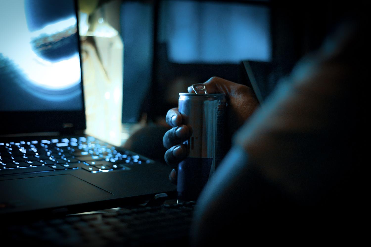 Uso de un portátil en un entorno oscuro con el teclado iluminado, ilustrando la importancia de ajustar el brillo y activar el modo oscuro para ahorrar energía.