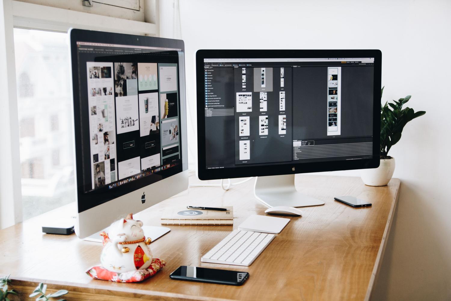 Estación de trabajo profesional con dos pantallas iMac, perfecta para gestionar múltiples escritorios virtuales.