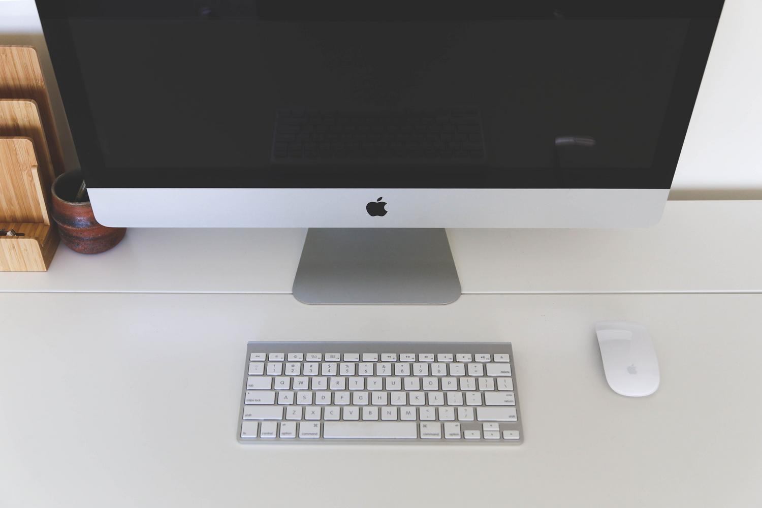 Espacio de trabajo minimalista con un iMac sobre un fondo blanco, simbolizando la limpieza visual.