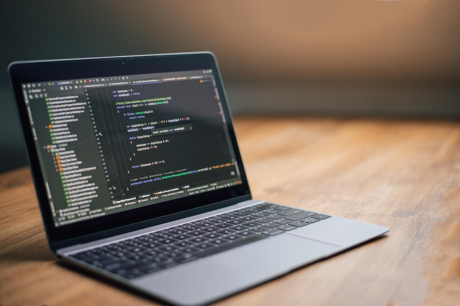 Detalle técnico de un editor de código en modo oscuro en un portátil, resaltando la sintaxis de programación. Detalle técnico de un editor de código en modo oscuro en un portátil, resaltando la sintaxis de programación.