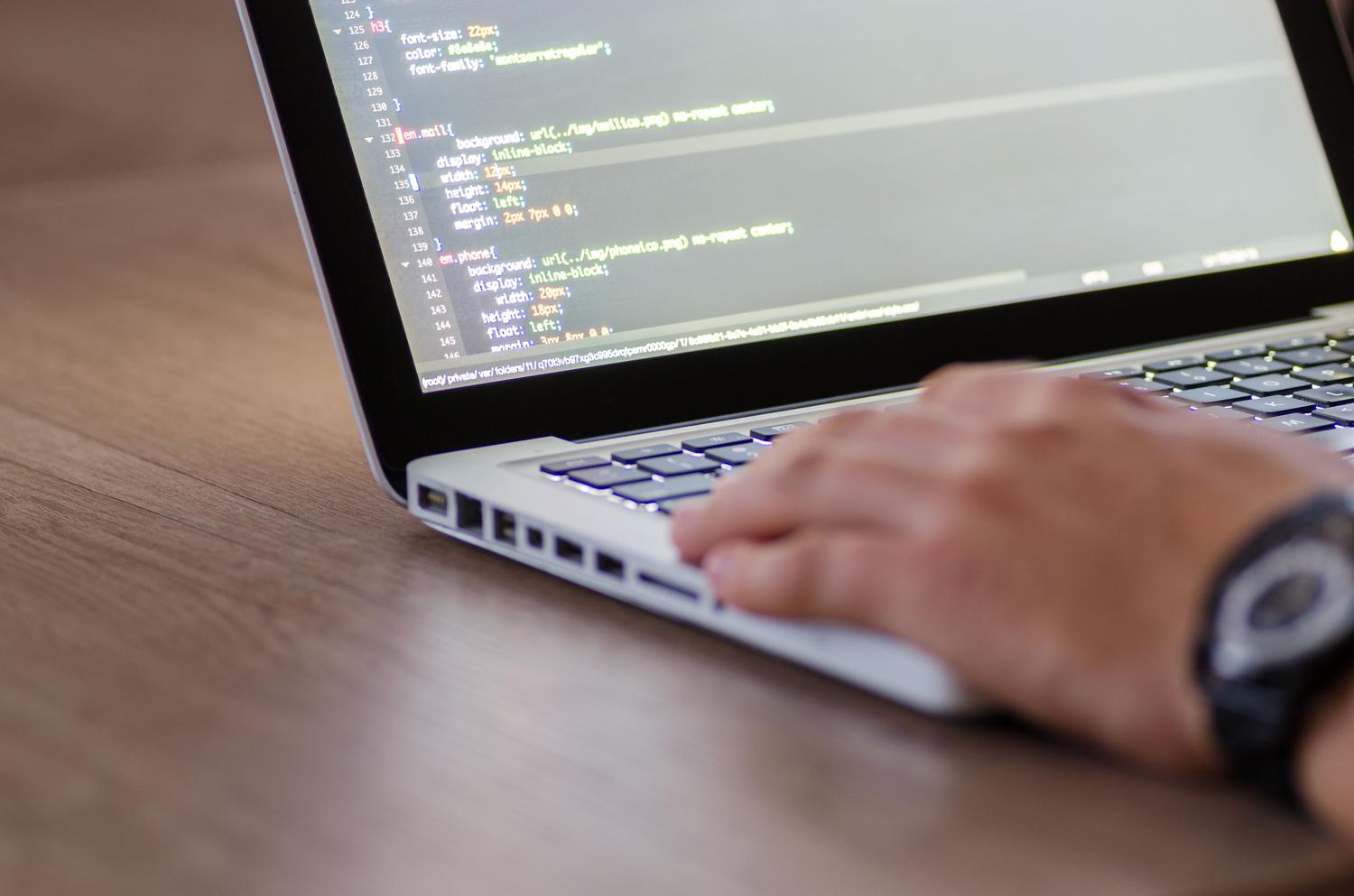 Primer plano de una persona programando código CSS en un portátil, representando el desarrollo web. Primer plano de una persona programando código CSS en un portátil, representando el desarrollo web.