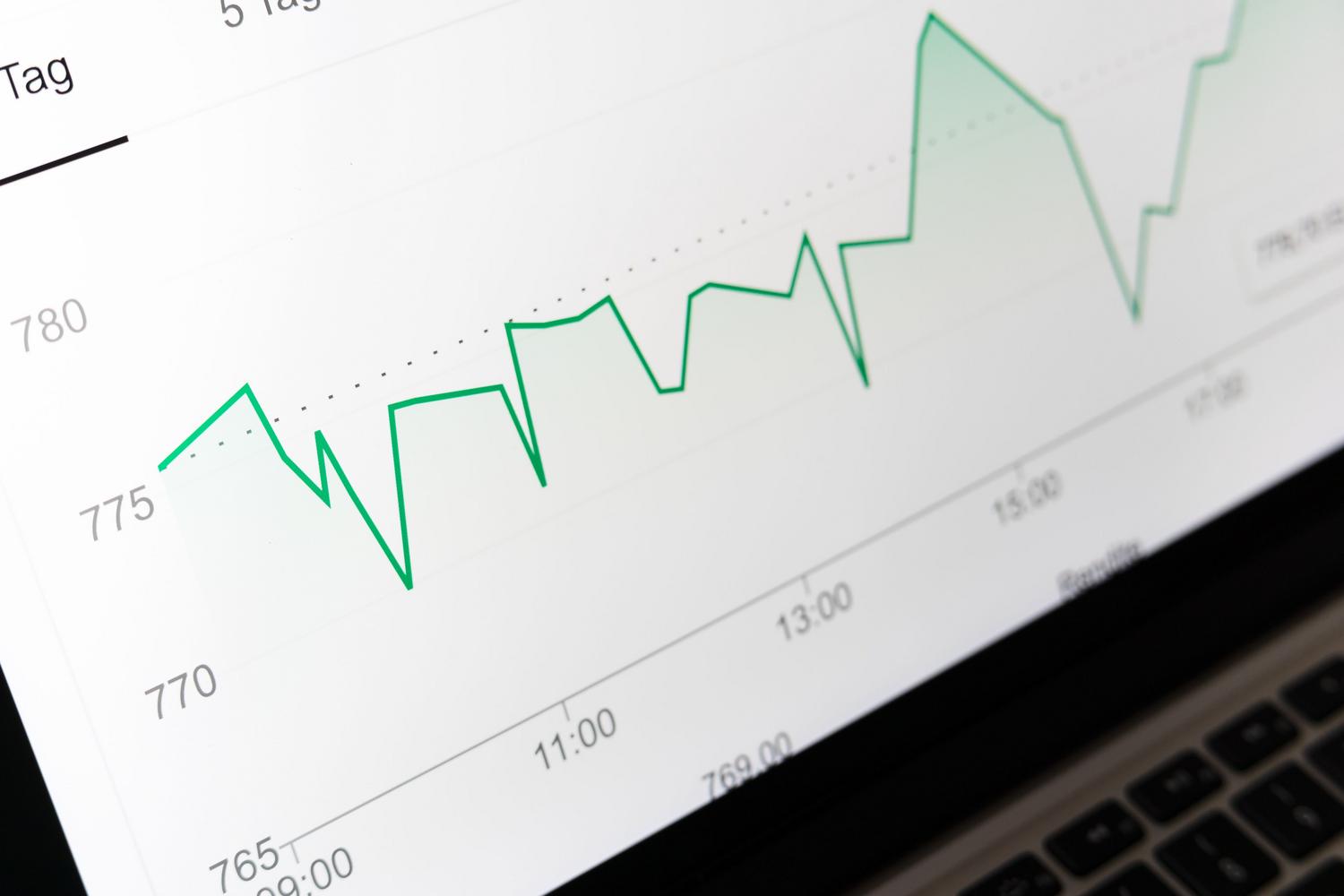 Primer plano de un gráfico financiero en la pantalla de un portátil, representando el análisis de tendencias de datos