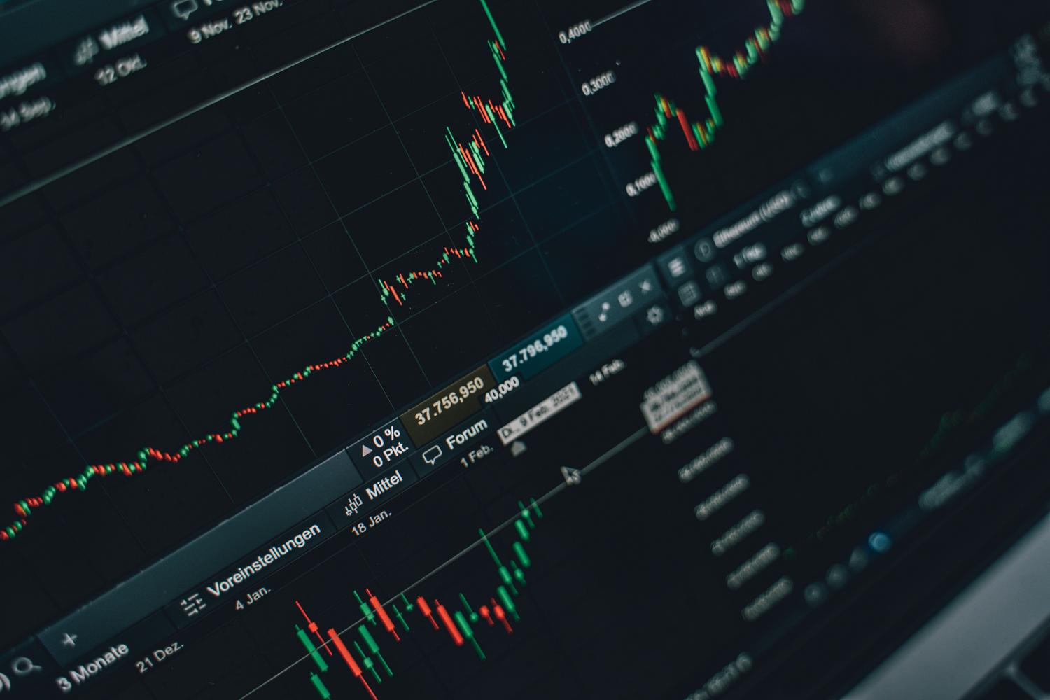 Pantalla de trading con gráficos de velas japonesas mostrando tendencias alcistas en el mercado financiero