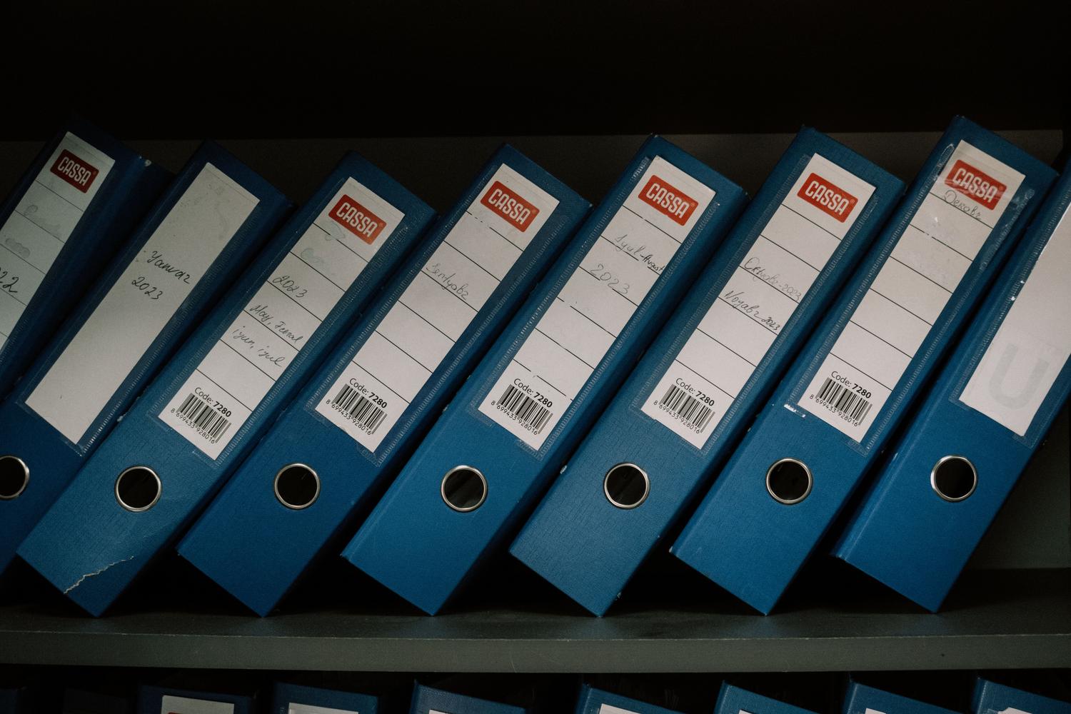 Carpeta de archivos azules organizados meticulosamente en un estante, representando el concepto de un índice de búsqueda.