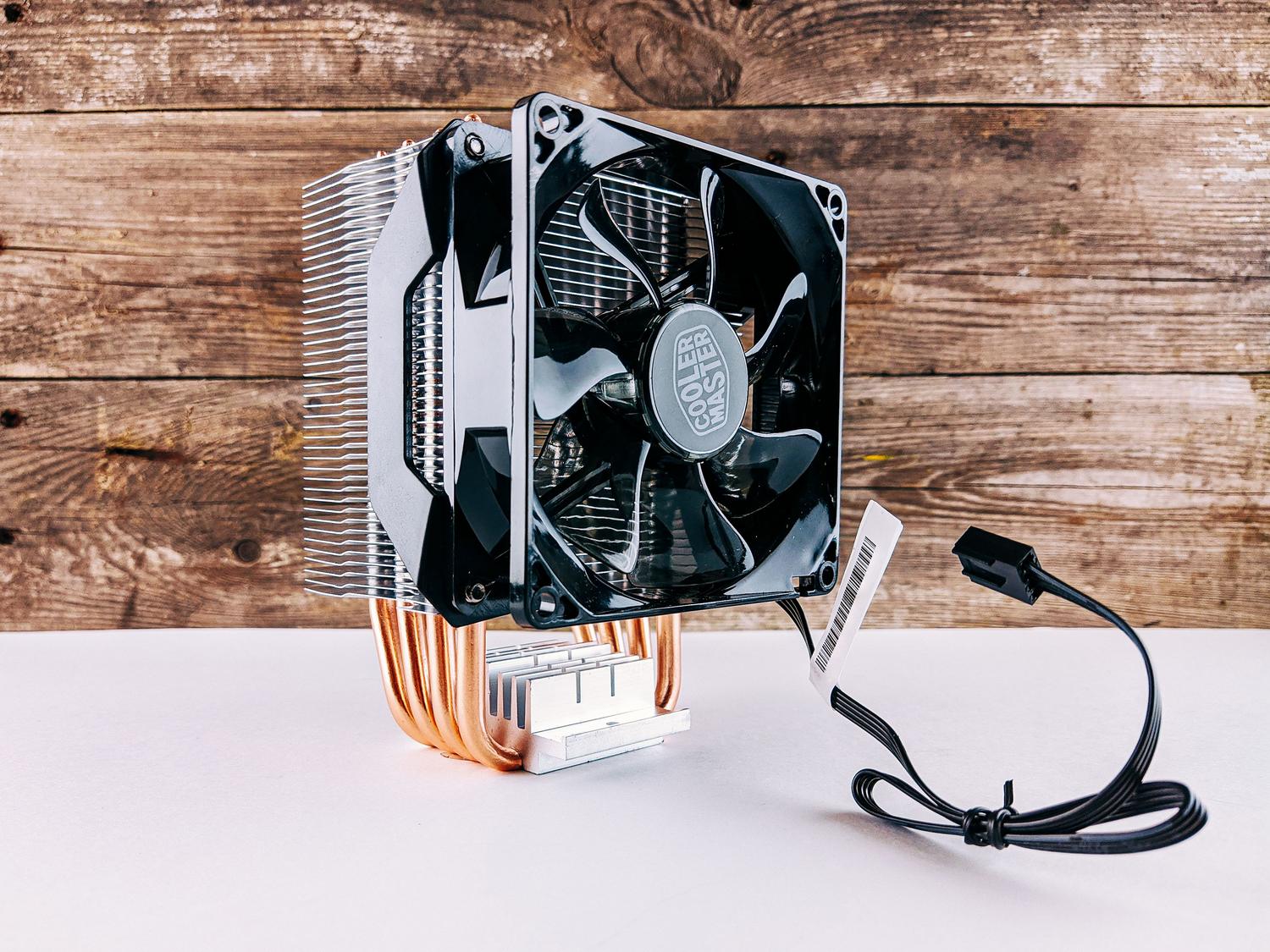 Detalle de un ventilador de refrigeración de CPU y su disipador sobre un fondo de madera