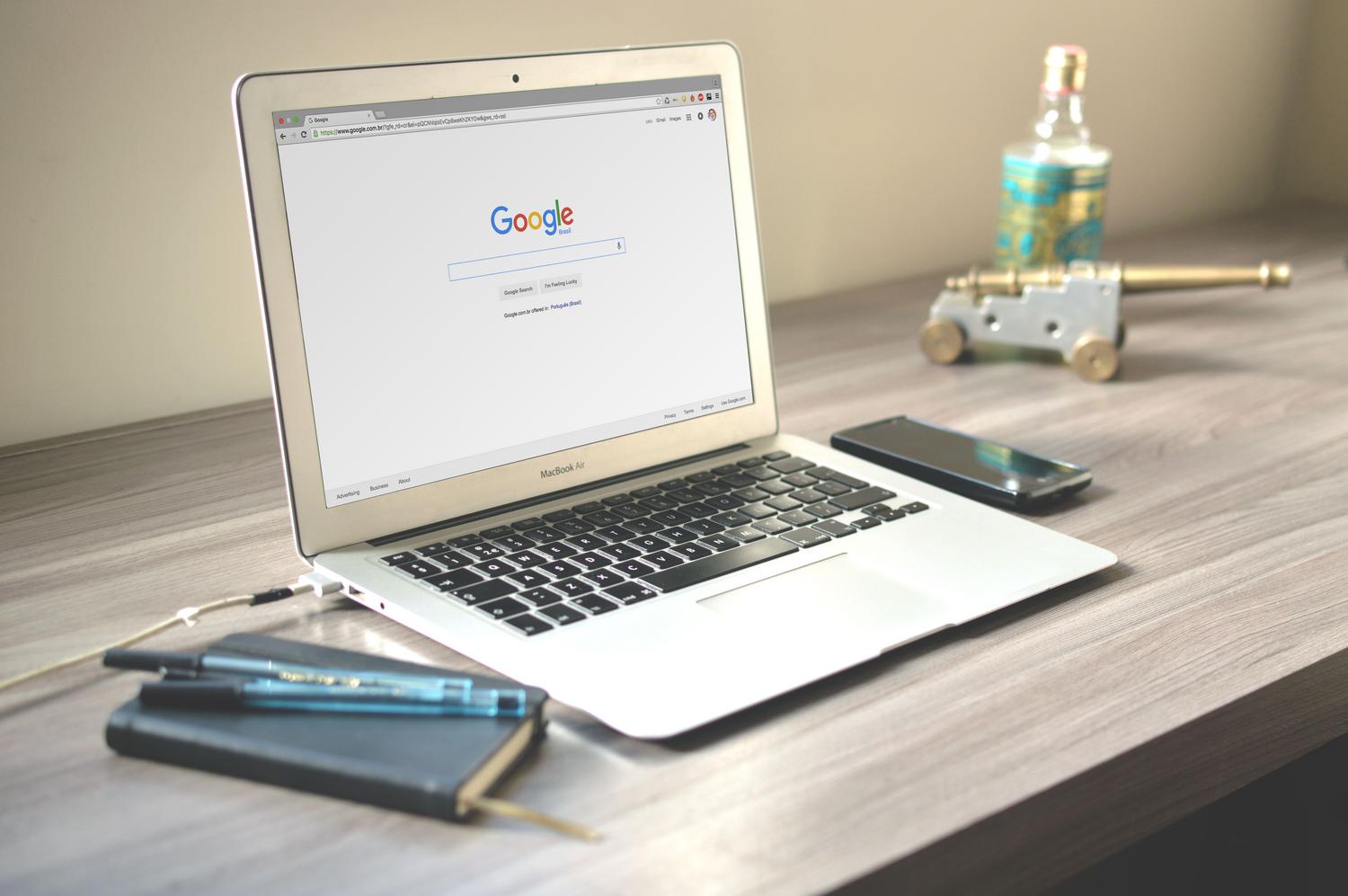 MacBook Air con el buscador de Google en pantalla sobre un escritorio ordenado, ideal para ilustrar la navegación en Chrome.