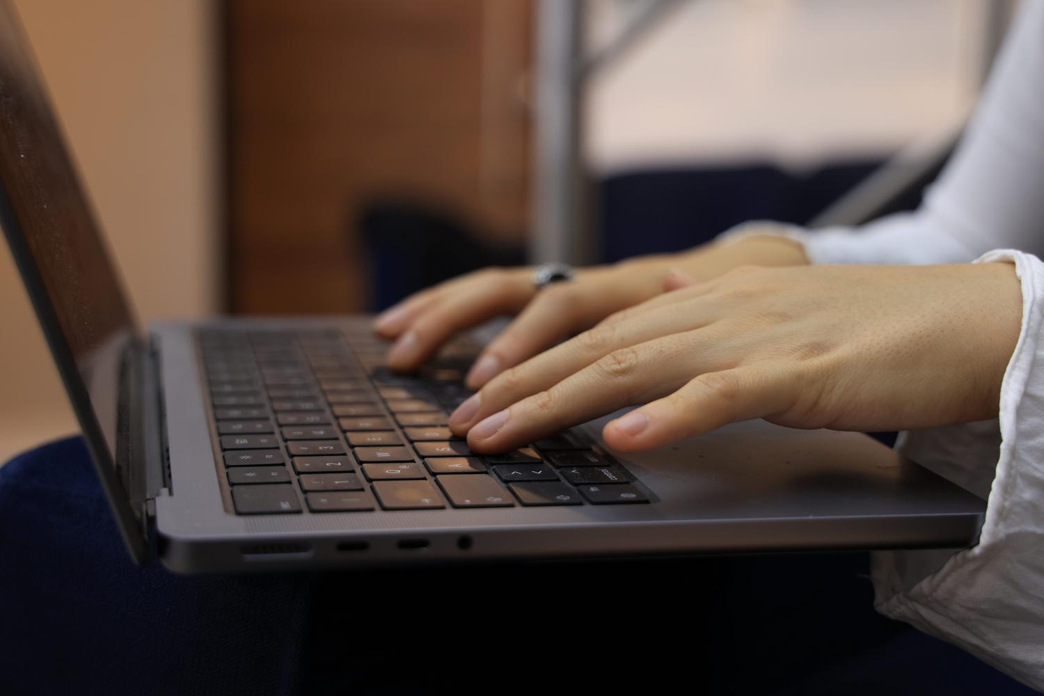 Detalle de manos trabajando en el teclado de un ordenador, sugiriendo la ejecución de procesos de mantenimiento y reparación del sistema.