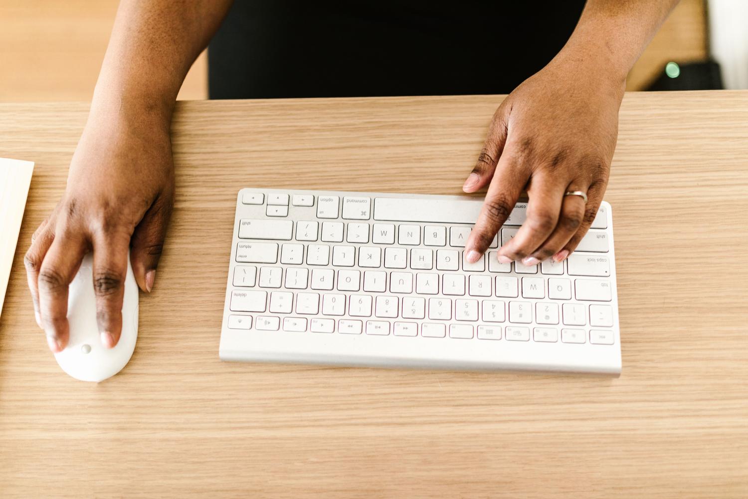 Imagen luminosa de un teclado y ratón blanco sobre un escritorio, transmitiendo la sensación de un problema resuelto y el retorno a la productividad.