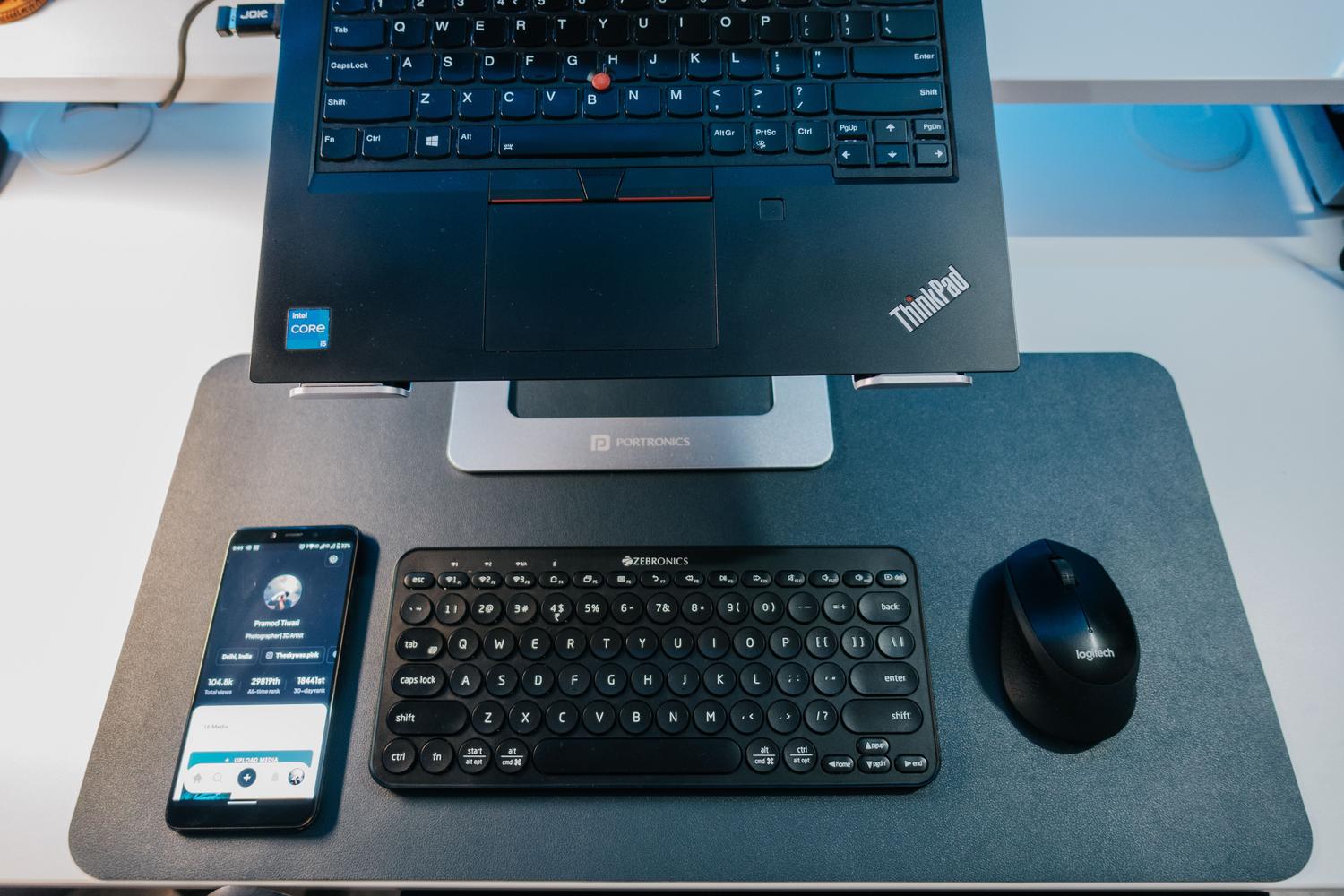 Espacio de trabajo moderno y minimalista con portátil, teclado y ratón inalámbricos conectados vía Bluetooth.