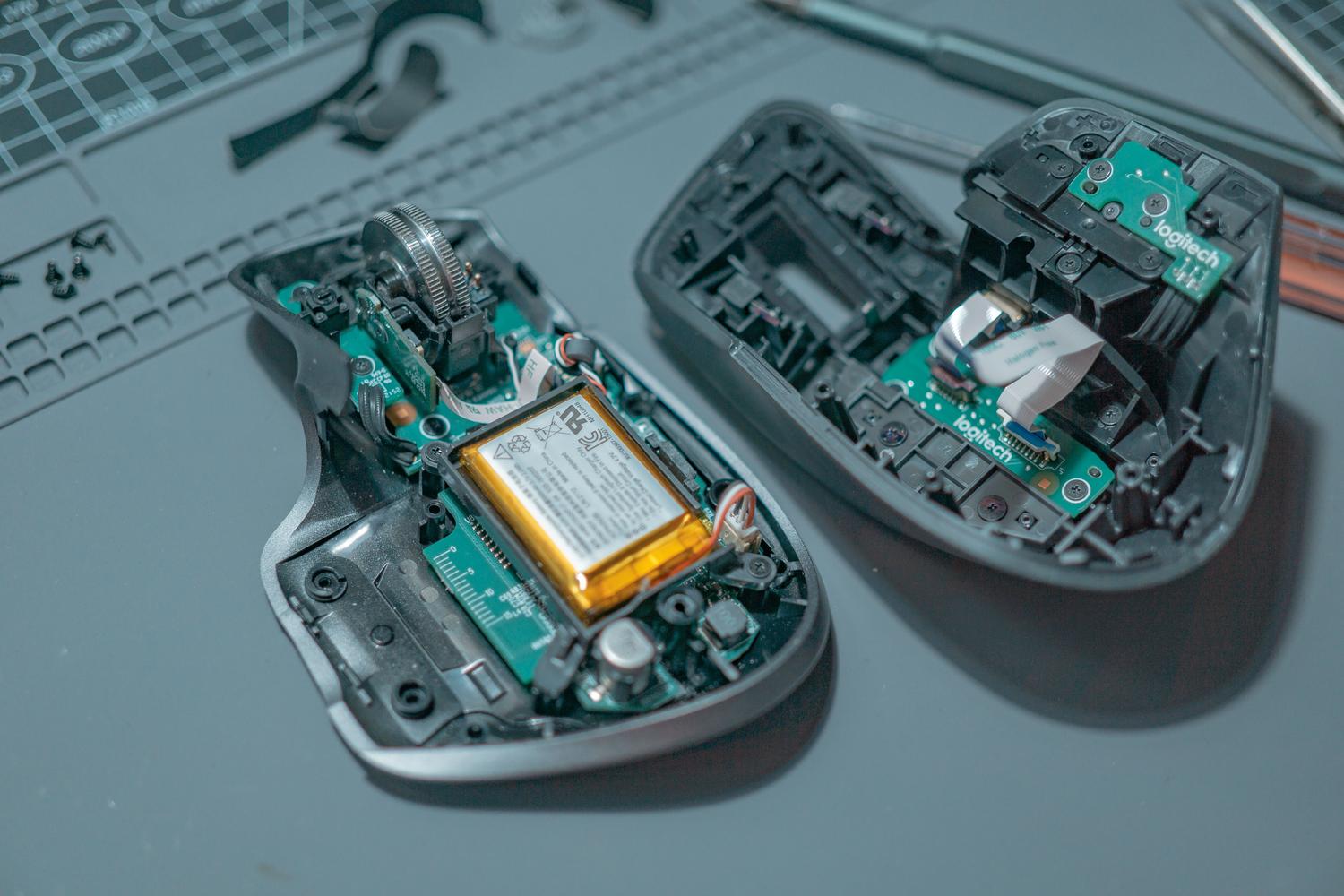 Interior de un ratón inalámbrico desmontado mostrando la placa de circuito y la batería interna.
