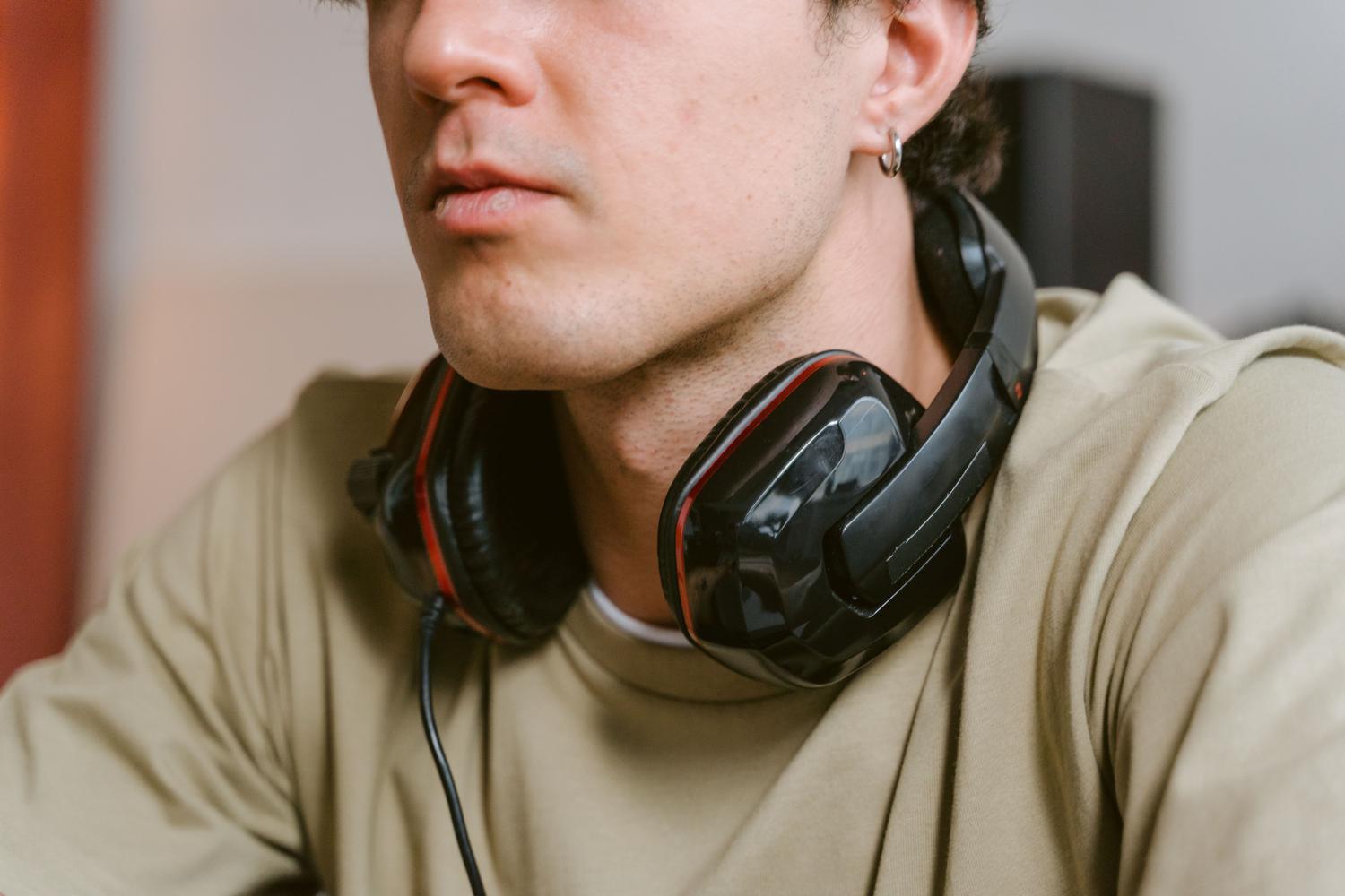 Hombre con auriculares alrededor del cuello, representando la experiencia del usuario al gestionar su equipo de sonido.