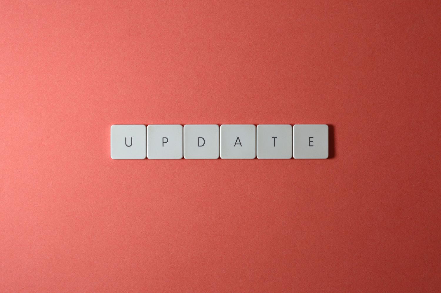 Teclas de un teclado mecánico formando la palabra 'update' sobre un fondo rojo vibrante, ilustrando el concepto de actualización de Windows.