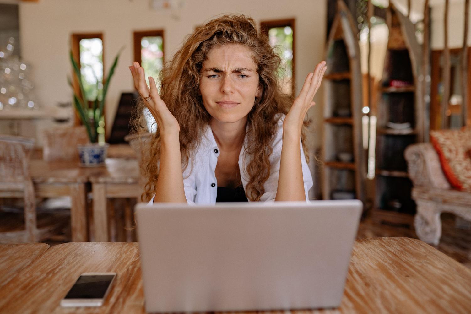 Mujer frustrada frente a su ordenador portátil debido a un error de sistema, representando el estrés que causa el código 0x800f081f.