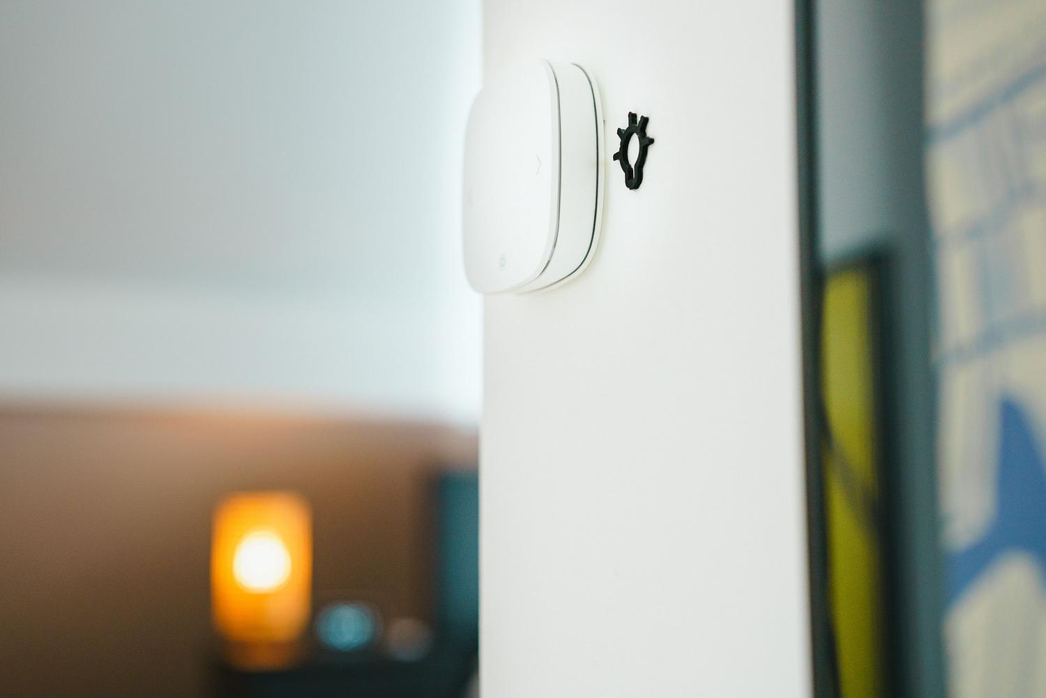 Primer plano de un interruptor de luz inteligente instalado en una pared blanca.
