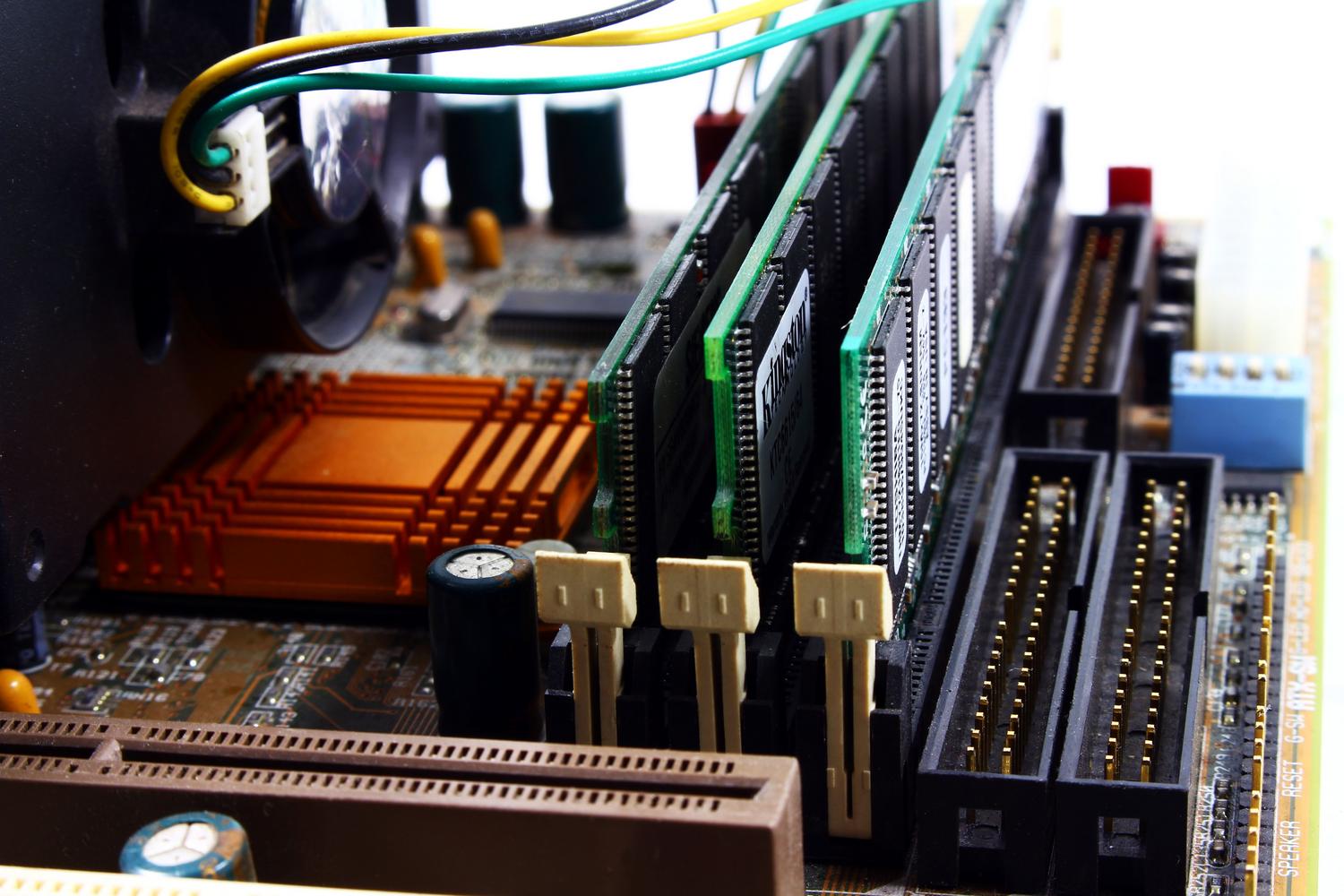 Primer plano detallado de una placa base de ordenador, representando la comunicación entre el hardware y los controladores (drivers).