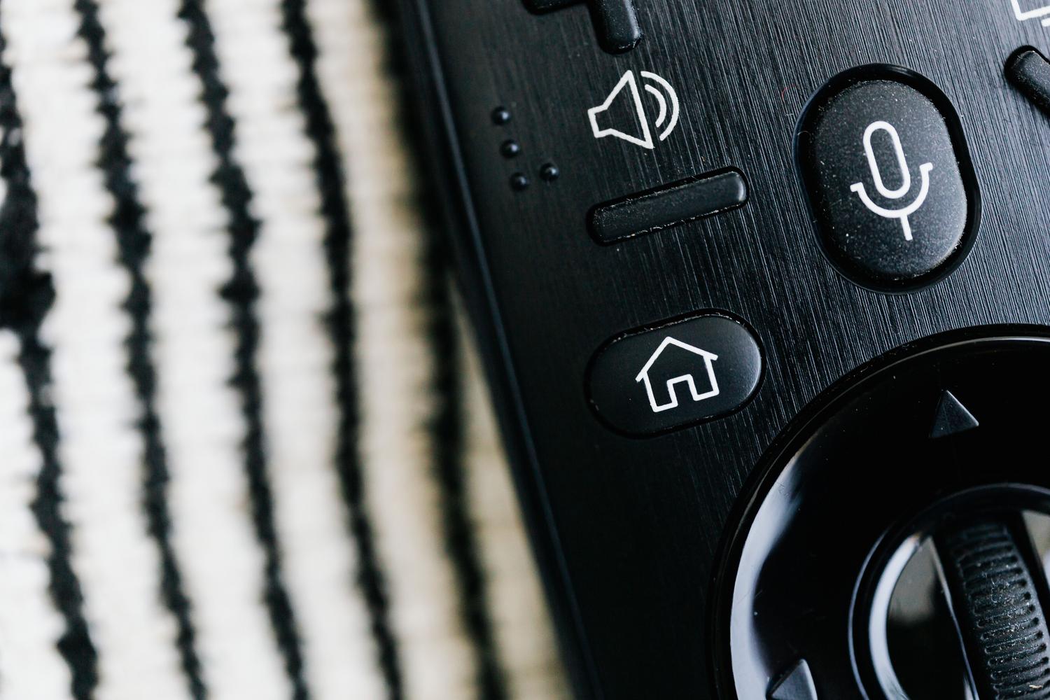 Primer plano detallado de un mando a distancia negro moderno para Smart TV.